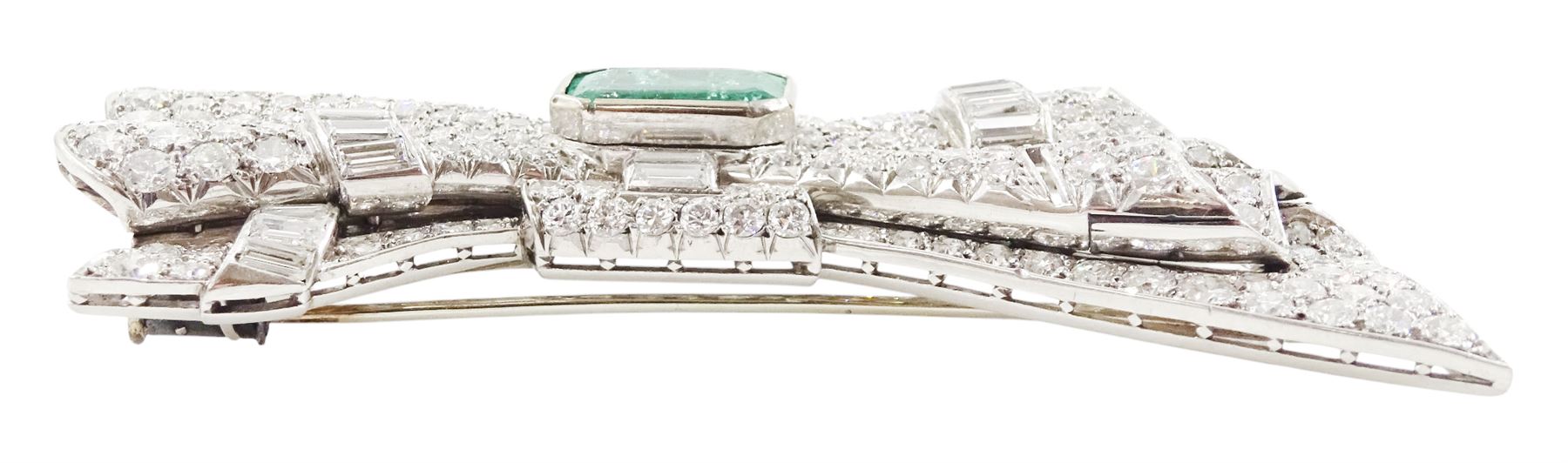 Platinum emerald and diamond bow brooch, central octagonal cut emerald of approx 4.00 carat, with round brilliant and baguette cut diamond surround, total diamond weight approx 23.00 carat