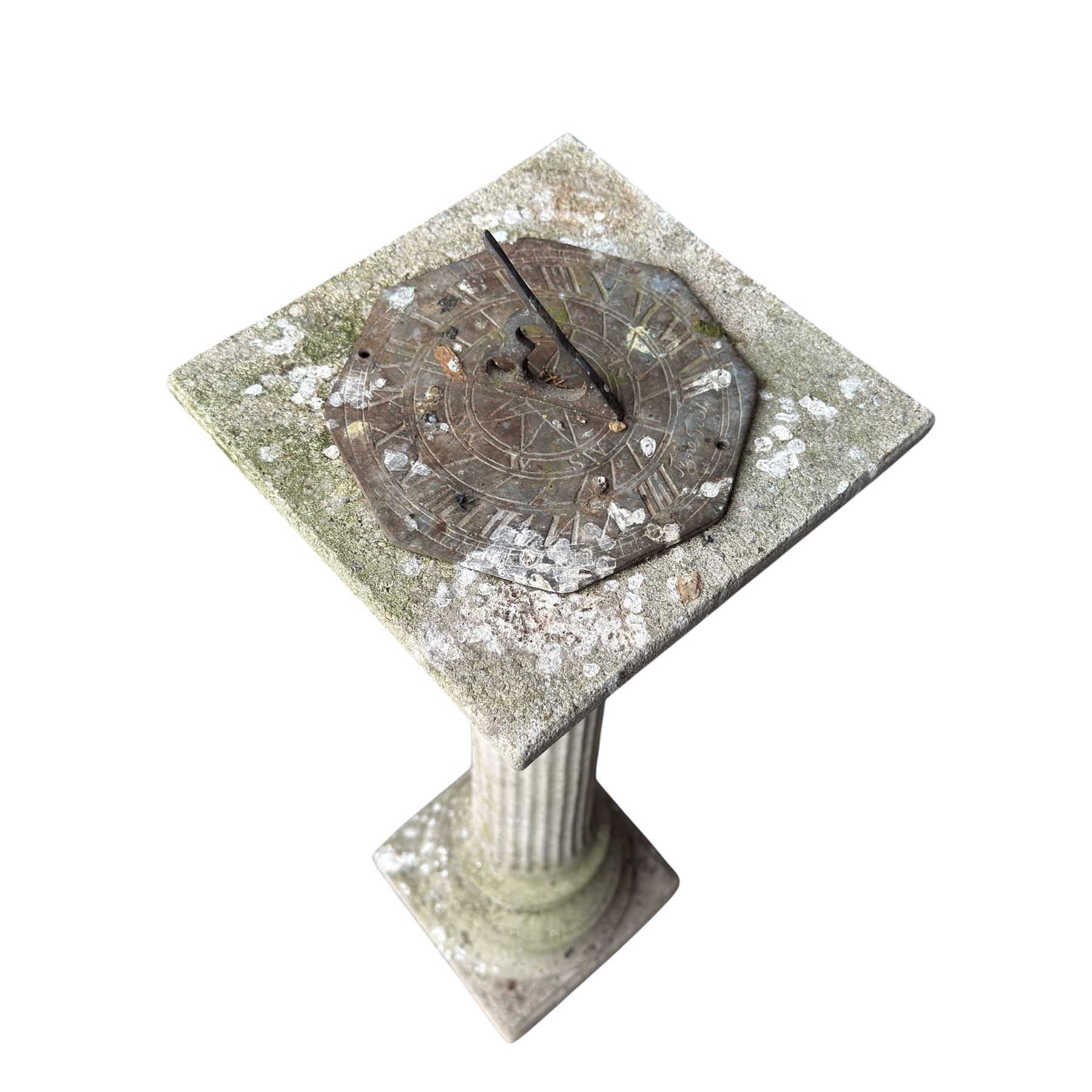Weathered cast stone sundial on fluted pedestal