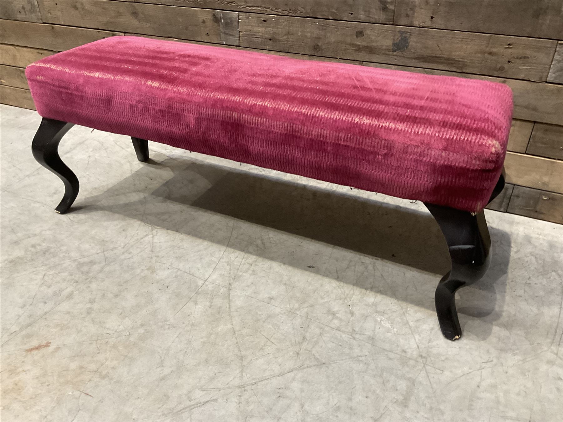 Large rectangular footstool upholstered in a maroon fabric with cabriole supports