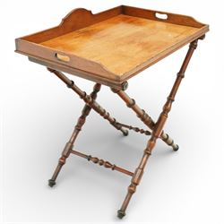 19th century coaching table, the rectangular tray top with shaped gallery and cut out carrying handles, raised on a folding X frame stand with turned supports and stretcher rails