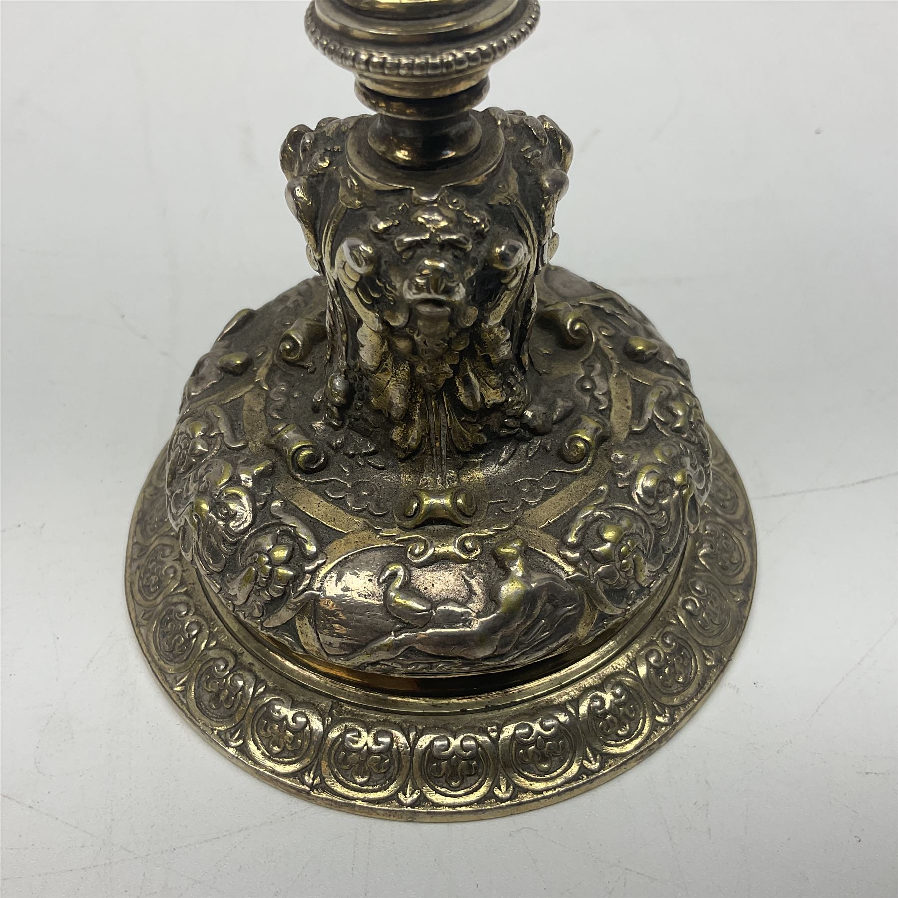 Pair of Victorian Elkington Mason & Co silver plated candlesticks, decorated in relief with ram masks and figures, H14cm