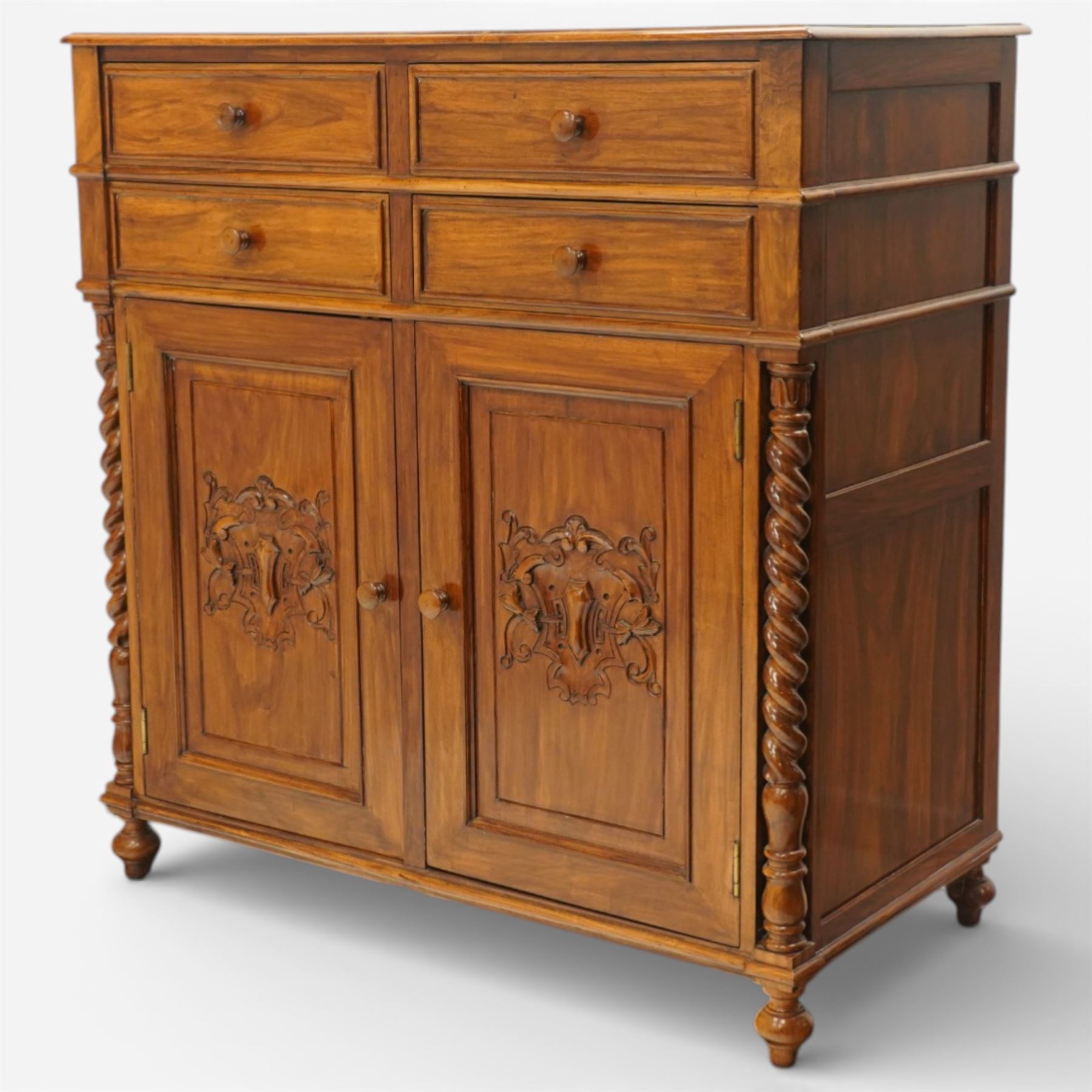 Victorian design rosewood side cabinet, the rectangular moulded top above four frieze drawers with turned wooden knob handles, over twin cupboard doors carved with foliate panels, flanked by barley twist uprights, upon turned bun feet