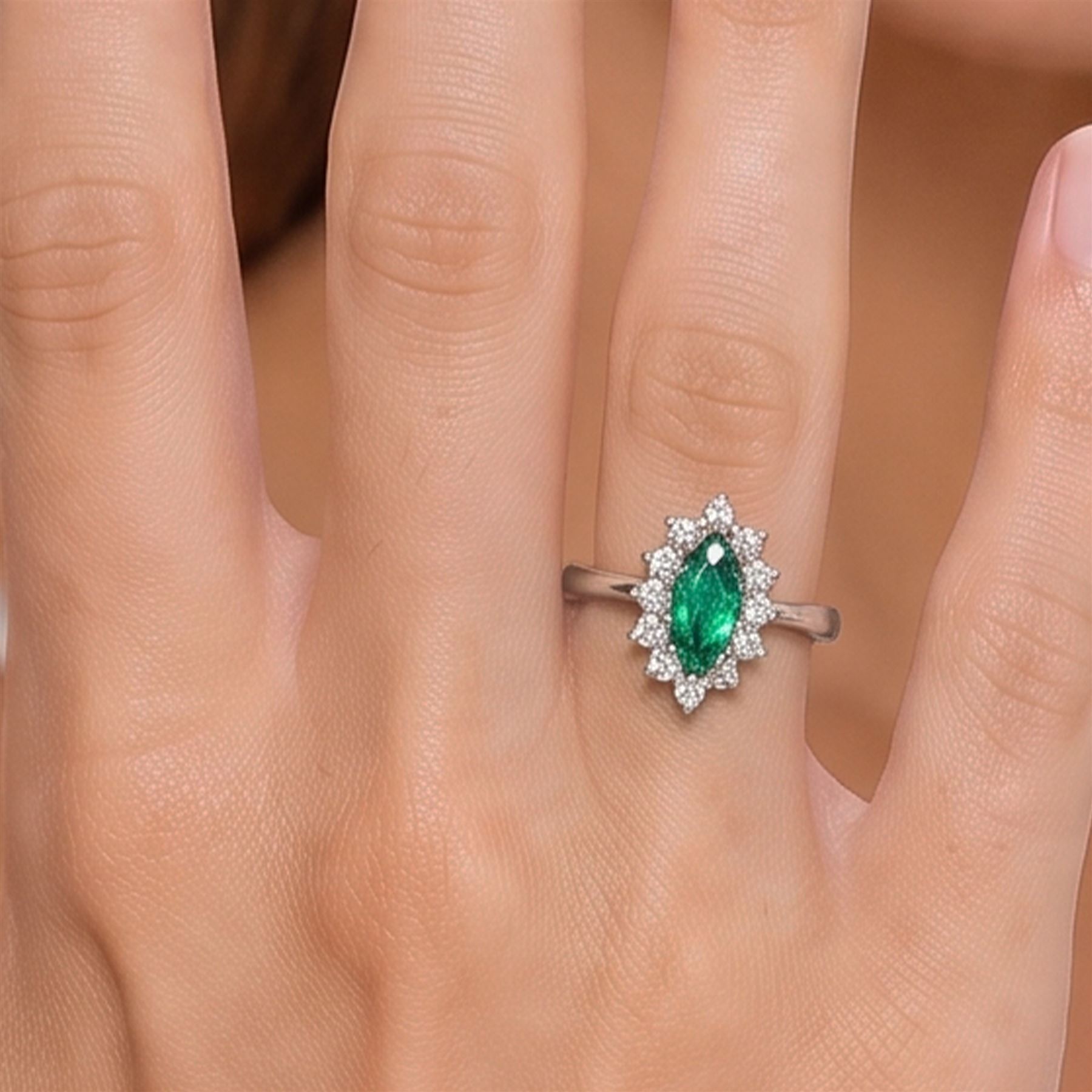 18ct white gold emerald and diamond cluster ring, single marquise cut emerald 0.25 carat, surrounded by twelve round brilliant cut diamonds, London 1979, total diamond weight approx 0.25 carat