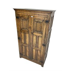 Mid-to-late 20th century oak double wardrobe, enclosed by panelled doors with linenfold decoration