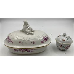 20th century Meissen dish and cover, of oval form, decorated with puce floral sprays and sprigs, the cover with figural finial, L17.5cm, together with a small 20th century Meissen bowl and cover decorated in the Kakiemon style, H6cm, each with underglaze blue crossed swords mark beneath