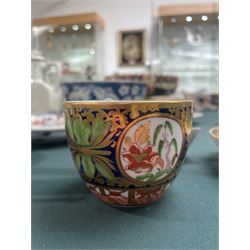 19th century teacup and saucer, possibly Coalport, decorated with panels of flowers on a cobalt blue ground with gilt decoration; together with two other teacup and saucer pairs, one with hand painted landscape decoration 