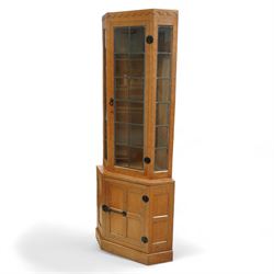 Mouseman - oak corner display cabinet, arched dentil carved cornice over leaded glazed doo...