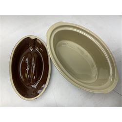 Emile Henry covered casserole dish of oval form in two tone brown and cream, no. 03.06, together with cast iron Nomar twin handled lidded casserole dish of oval form in navy, and other ovenware including Flintware ICTC, largest L35cm