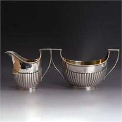 Victorian silver four piece tea service, comprising coffee pot, teapot, twin handled open sucrier and milk jug, all of oval part fluted form and engraved with initial to body, the coffee pot on oval stepped foot, coffee pot and teapot with ebonised wooden finials, hallmarked Elkington & Co, Birmingham 1888