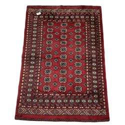 Turkmen Tekke Bokhara rug, red ground and decorated with Gul motifs, repeating multi-band border, signed on corners 