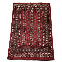 Turkmen Tekke Bokhara rug, red ground and decorated with Gul motifs, repeating multi-band border, signed on corners 