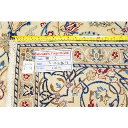 Central Persian Nain hand-knotted carpet, ivory field with central finely drawn cusped medallion of radiating palmette and arabesque form with scrolling vine work, flowering tendrils and stylized foliate motifs in a palette of pale blue, indigo, crimson and sage accents, spandrels of conforming design enclosing intricate floral sprays and arabesques within  multiple borders and narrow guard stripes, with cotton fringe ends 