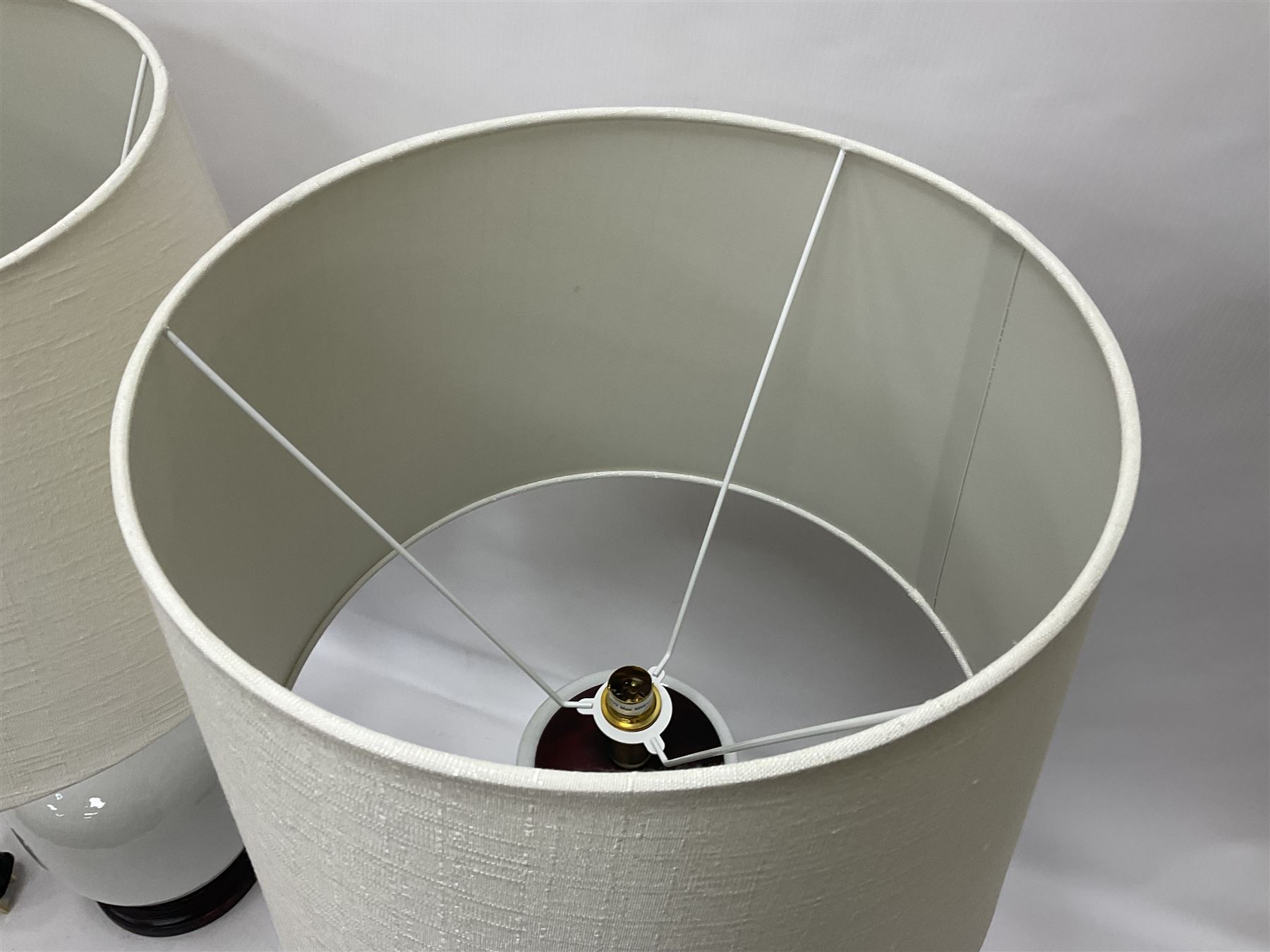 Pair of Chinese ivory crackle glazed table lamps, each of bottle form, raised upon circular hardwood base, excluding fittings H43cm