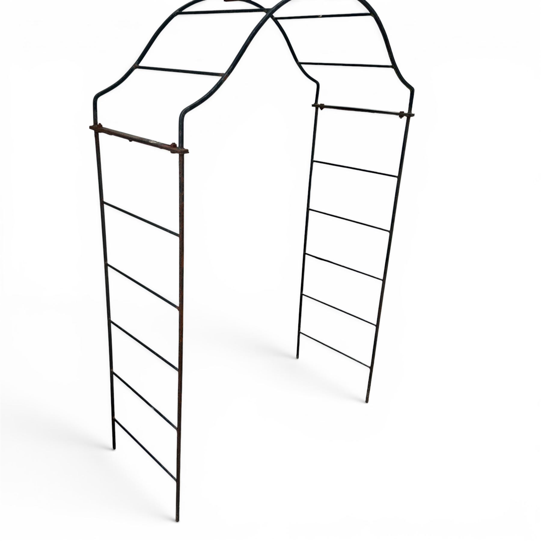 Antique wrought iron strapwork garden arch, with scroll form arched top with spearhead finials, over integral side trellis panels, in distressed black-painted finish