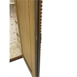 Early 20th century Italian walnut armoire wardrobe, the pierced and scrolling pediment carved with acanthus leaf detail, flanked by two scrolling cartouche with matching corbels below, the two panelled doors with applied carved rinceaux slips, with a central spiral turned upright, enclosing single shelf and hooks, raised on scroll feet