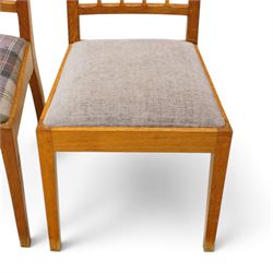 Acorn Industries - set of eight oak dining chairs, the shaped cresting rail over a fluted stick back, the drop-in seats upholstered in contrasting form with four pale mauve and four in purple tartan, raised on square supports, carved with acorn signature, by Alan Grainger, Brandsby