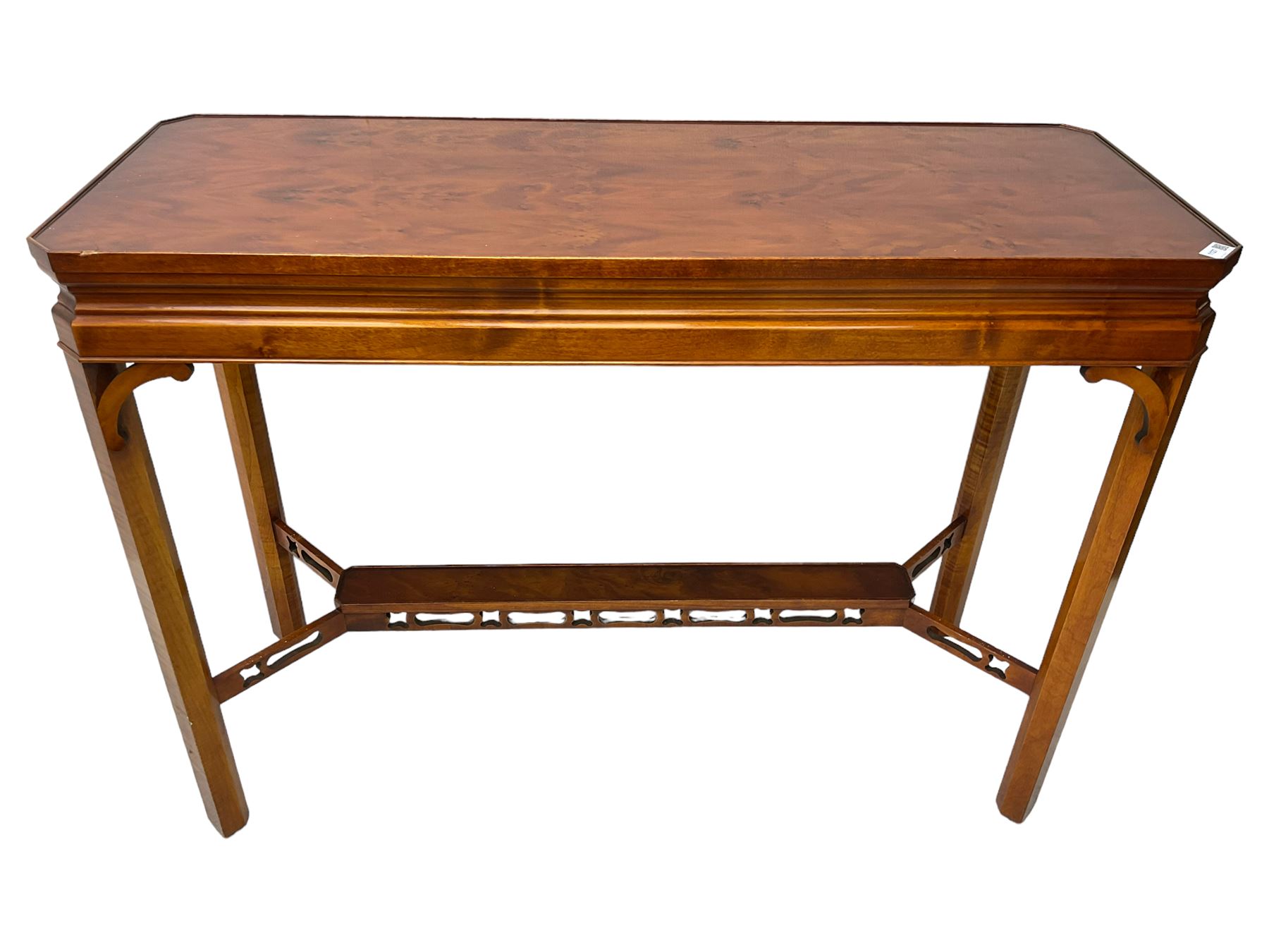 Wade - yew wood console table, rectangular top with canted corners and raised lipped edge, on chamfered square supports united by narrow under-tier