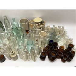A collection of assorted glass bottles, of various size and form, mostly clear and green glass examples, plus a small group of Stoneware jars. 