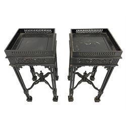 Pair early 20th century black lacquered urn stands, square top with fretwork gallery, on cluster column supports joined by shaped fretwork x-framed stretchers with turned finial, on block feet 