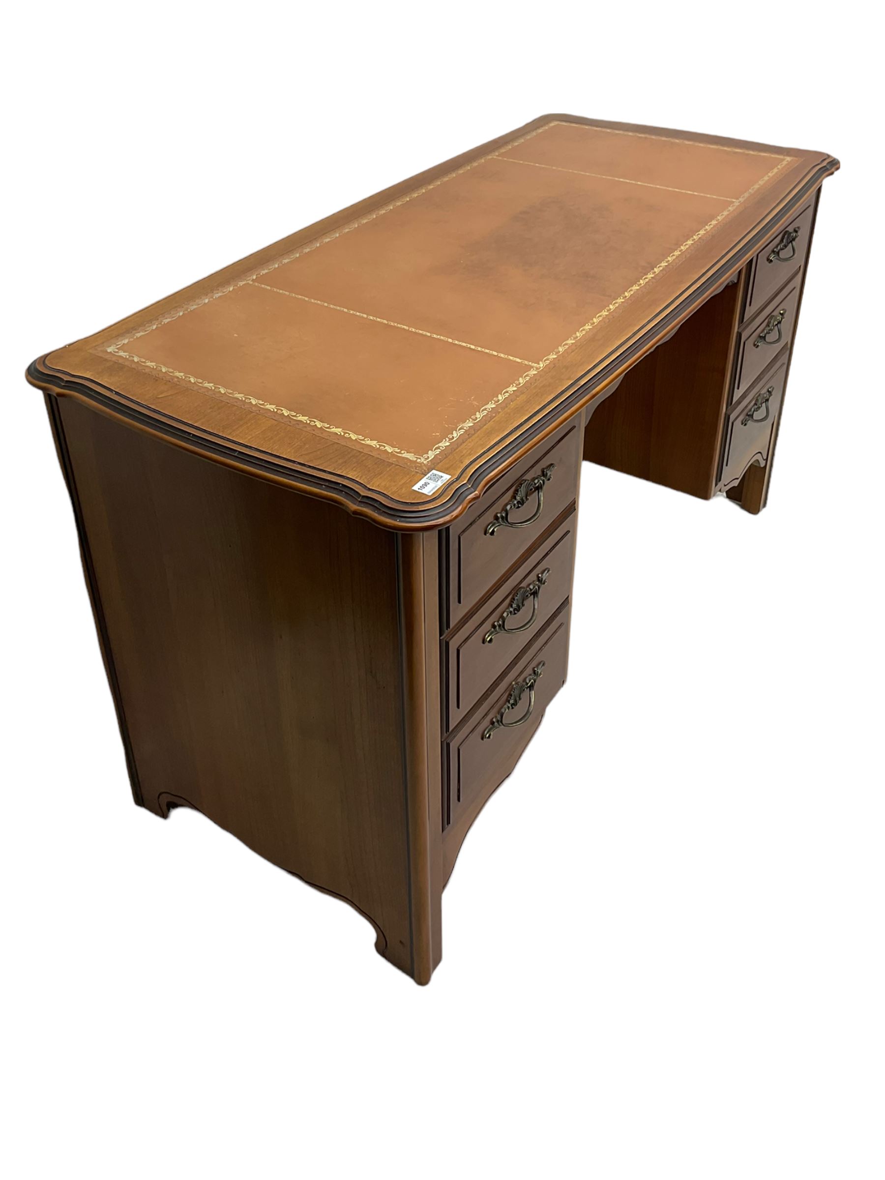 Younger Furniture - cherry wood desk, the shaped top with leather inset, fitted with six drawers