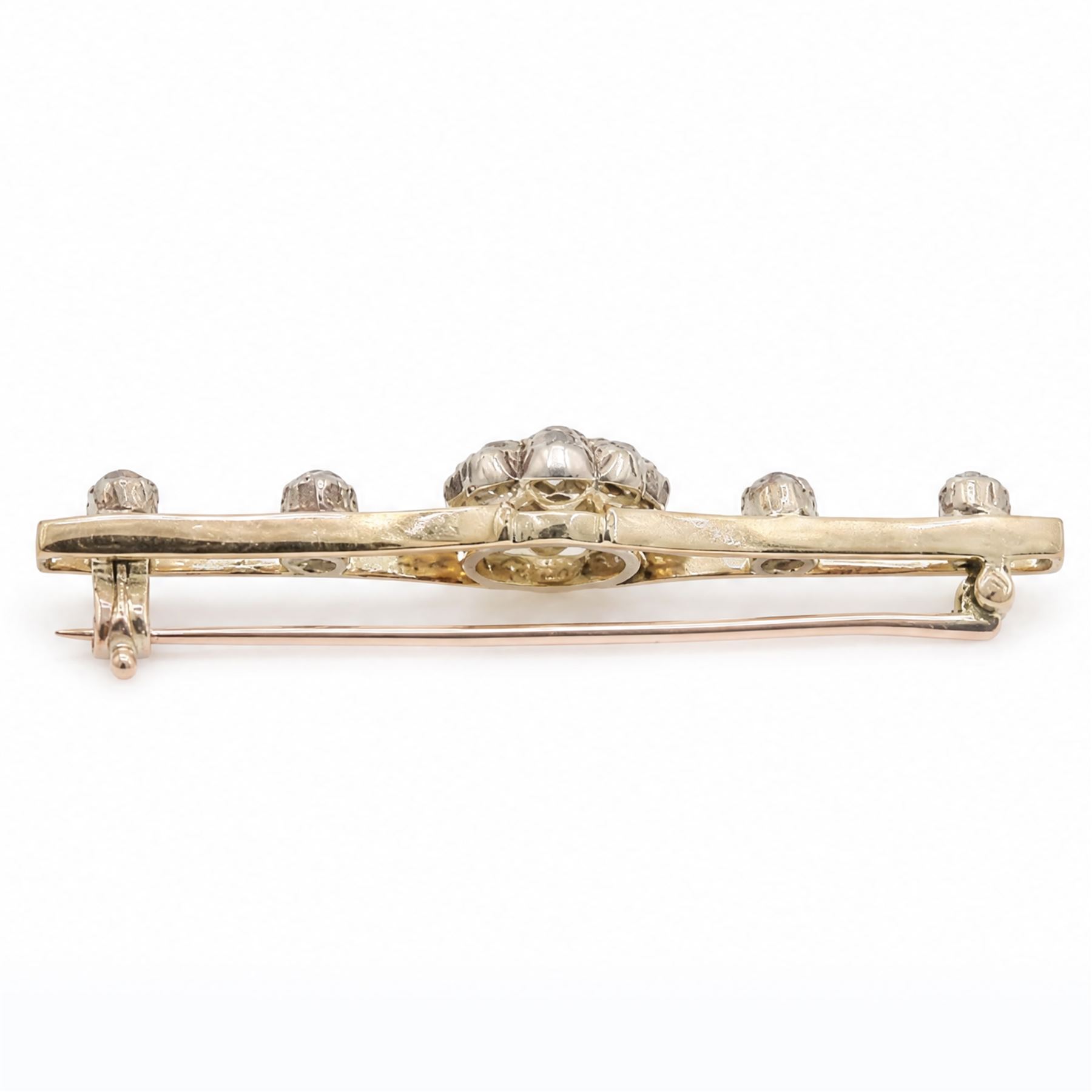 Early 20th century gold and silver diamond brooch, the flower head cluster set with nine old cut diamonds, to split design shoulders, either side set with two further diamonds, total diamond weight approx 1.25 carat