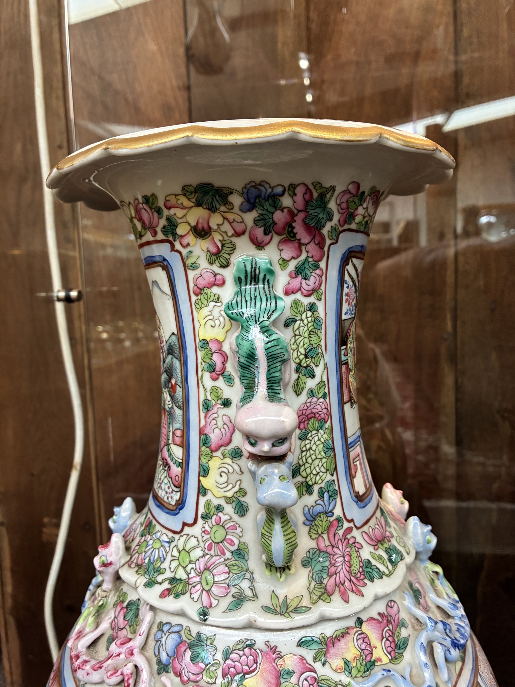 Large pair of 19th century Cantonese famille rose vases, each painted with various courtly scenes, including a display of warriors fighting on horseback before an official and his attendants, double Buddhist lion handles and applied at the shoulders with chilong, the lower band painted with Greek key motif, H58cm (2)