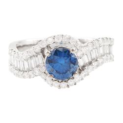18ct white gold diamond crossover ring, the principal round brilliant cut fancy blue diamo...