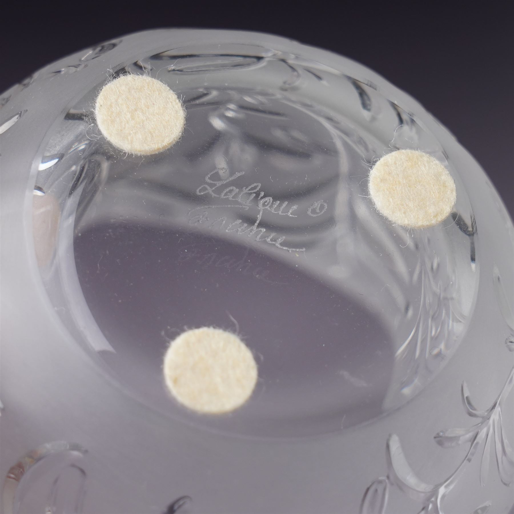 Three Lalique frosted glass tea light holders, decorated with the coriander and basil patterns, and another with trailing leaves, marked Lalique France to base, H7.5cm