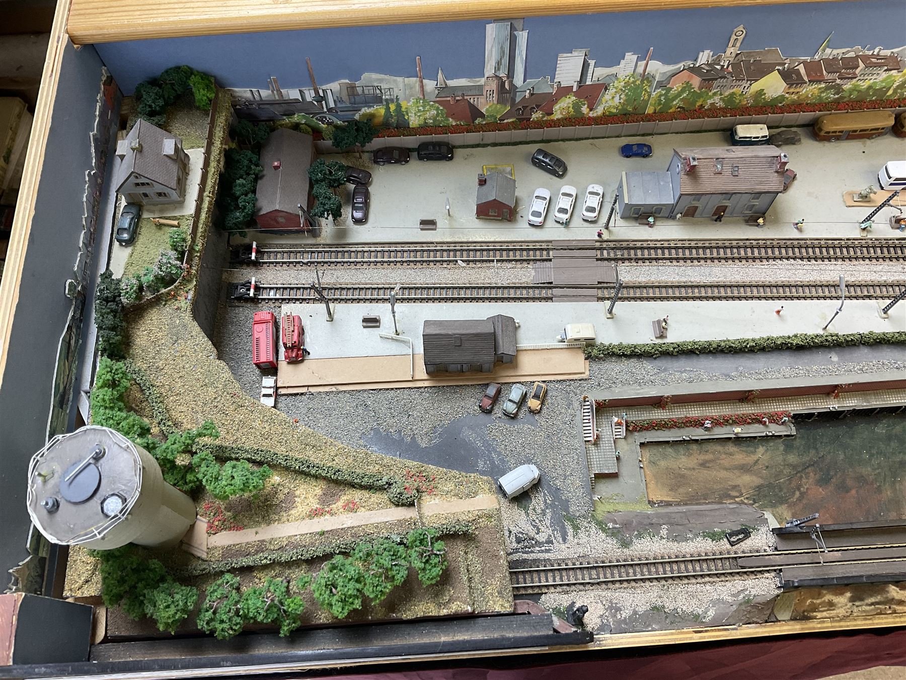 'Z' gauge continental scenic layout with folding legs, various loops of track and sidings with overhead cables, buildings including water tower, tunnels, roads with motor vehicles and figures, trees, haven with boats, backdrop diving wall hiding control units 150 x 50cm