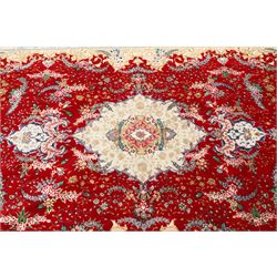 Fine Persian silk inlaid crimson ground Tabriz rug, the shaped field decorated with a central foliate pole medallion filled and surrounded by finely knotted floral motifs and trailing foliage, the cyan guard stripe with bold festoons and palmette motifs