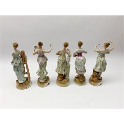 A group of five Continental figurines modelled as the arts, emblematic of music, painting, sculpture, literature, and theatre, each with spurious blue cross mark beneath, H22.5cm. (5). 
