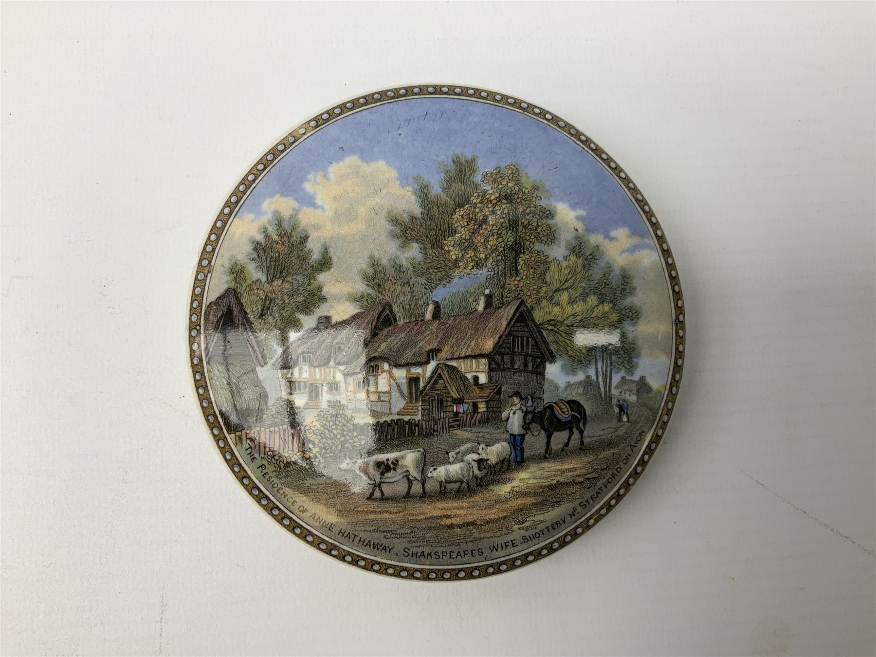 Late 19th Century pot lid bearing ‘The Residence of Anne Hathaway, Shakespeare’s Wife’ below printed decoration of thatched houses and animals scene, Royal Crown Derby Chinoiserie pattern coffee can and saucer, Rd No 758225, and an oval trinket box with gilt decoration bearing interlaced L mark to base (4)