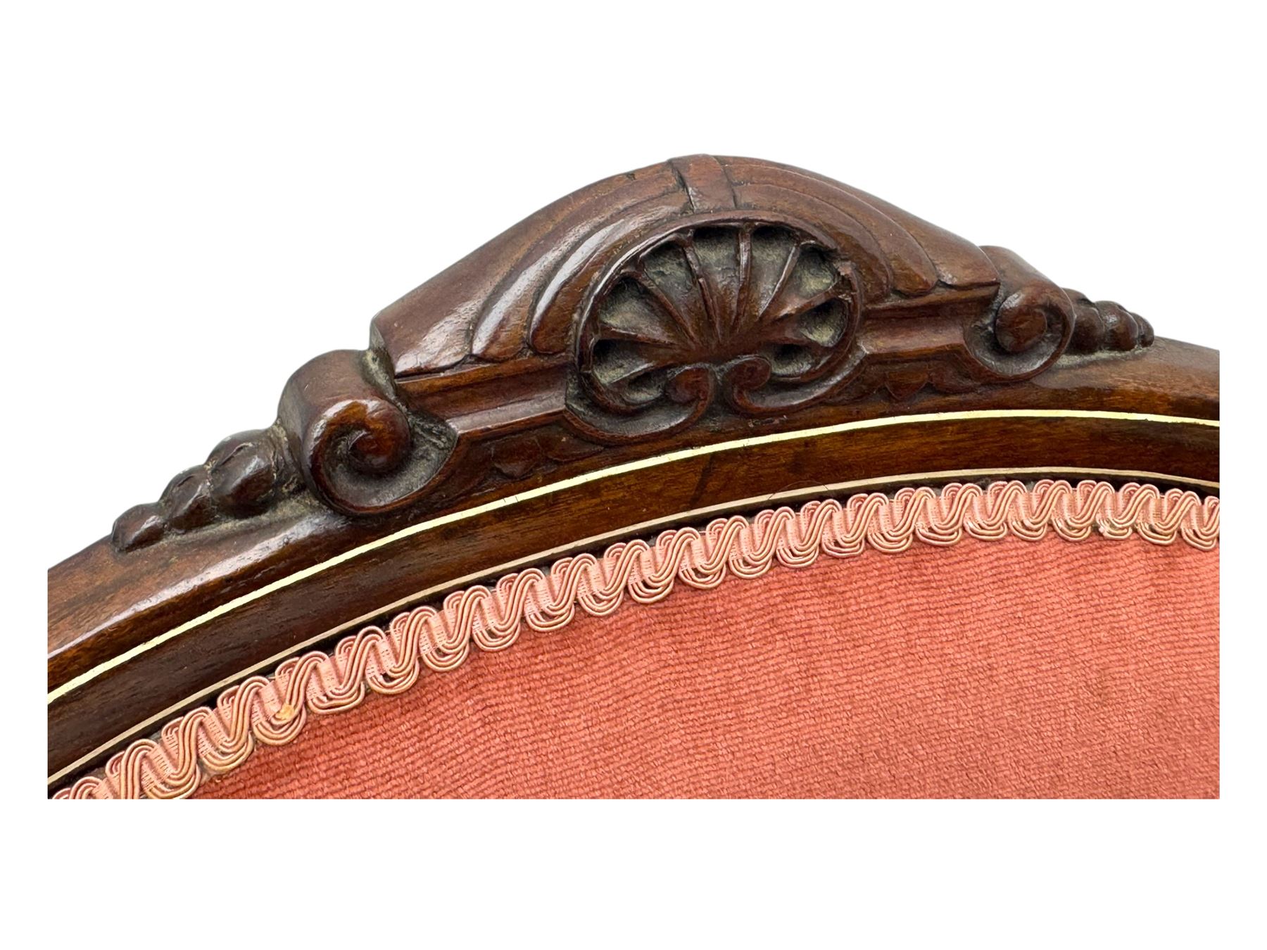 Pair of Edwardian inlaid rosewood salon chairs, upholstered in dusky pink fabric with gimp trim, oval backrest with carved crest rail with central shell motif and pierced splat, on cabriole supports terminating in castors