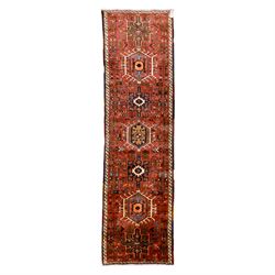 North West Persian Heriz hand-knotted runner, terracotta field decorated with a series of ...