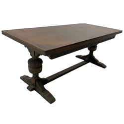 20th century oak drawer leaf extending dining table, two foliage carved baluster supports on sledge feet joined by floor stretcher 