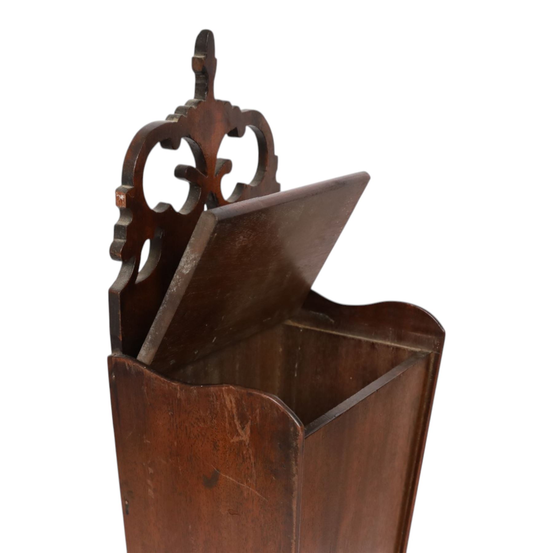 Three George III and later oak candle boxes, the first example of tapering form with shaped and pierced scroll crest, above a hinged lid, H50.5cm W18cm D13cm, the second of plain rectangular form with tapering crest, above a studded leather hinged sloped lid, H46cm W15.5cm D15.5cm, and third of plain rectangular form with demi-lune crest, with lift up front, H42.5cm W17.5cm D12cm 

