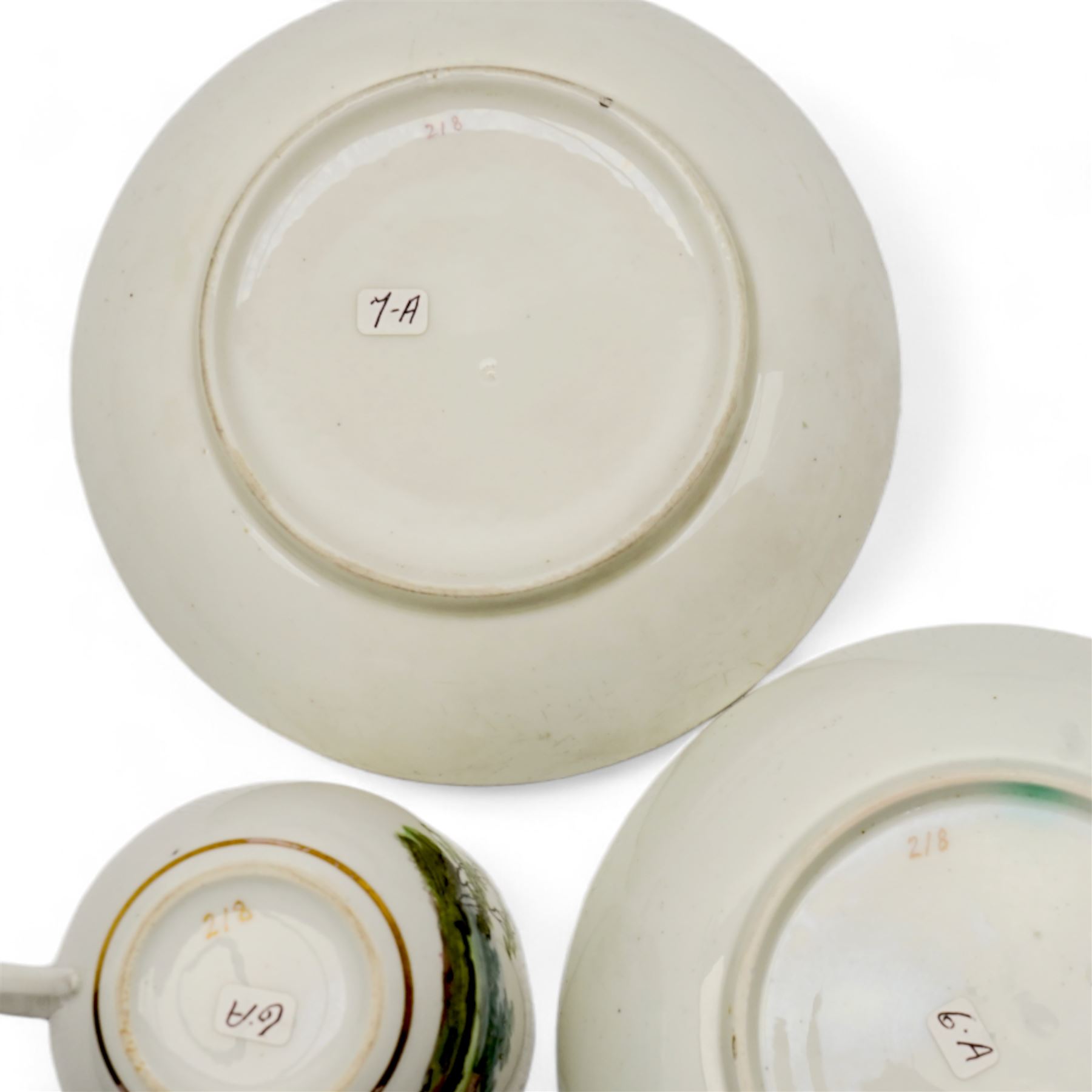 Set of four Pinxton porcelain bute shaped teacups and saucers, circa 1796-1813, pattern no. 218, painted in polychrome with landscape panels within gilt rims, possibly by John Cutts, three pieces numbered 218 beneath, saucer D14cm, teacup H6cm (8)