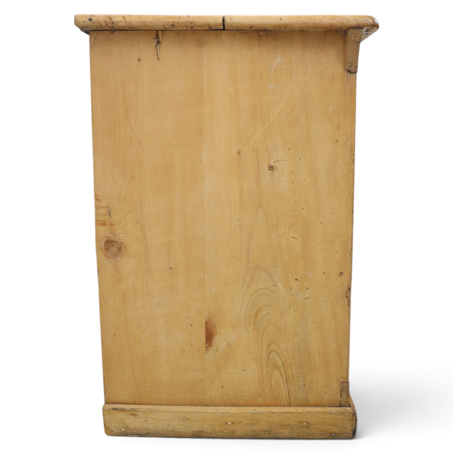 Victorian stripped pine sideboard, rectangular plank top rounded edges, with central cupboard door with shaped panel, flanked by two banks of three graduating drawers with turned knobs, raised on a plinth base 
