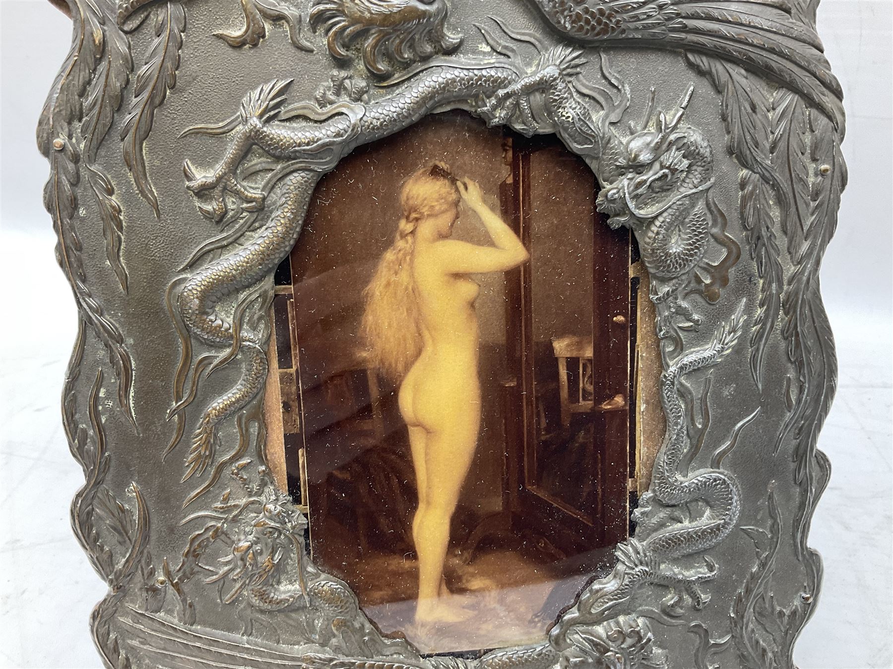 Japanese bronzed antimony frame, decorated with dragons and ho ho birds, easel stand to reverse, containing Continental crystoleum of female nude, H24cm