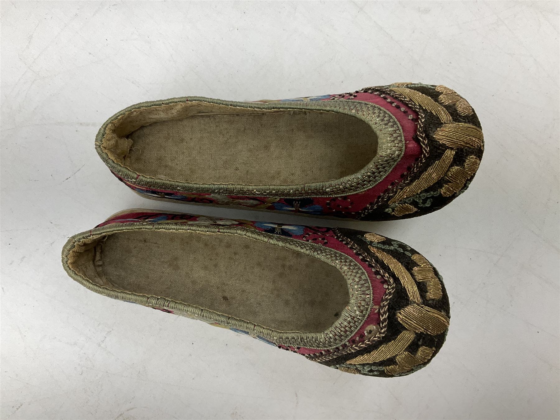 French silver plated wine taster of typical form, stamped, together with a silver plated napkin ring, and an 'Alpaca Silver' pill box with mother of pearl detailed cover, (3) together with Two pairs of late 19th/early 20th century Chinese Lotus shoes for binding feet, the first with purple silk heavily embroidered with ornate floral motifs, L10cm the second larger fuschia and black pair with thicker sole embroidered with flowers, L14cm