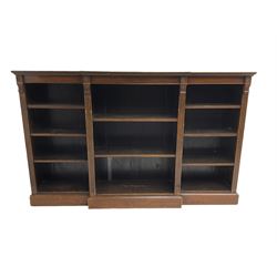 Edwardian mahogany breakfront bookcase, fitted with eight adjustable shelves, flanked by reeded uprights with corinthian capitals 