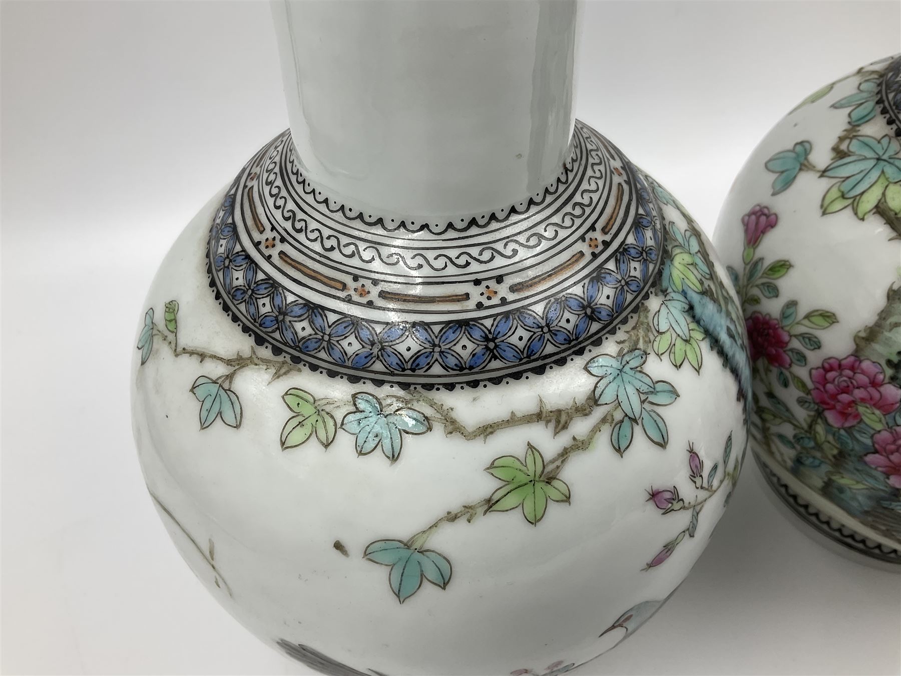 Pair of Chinese Republic porcelain vases, each painted in Famille Rose enamels with pairs of pigeons amidst peony, rock, flowering plants and leafy branches, possibly Qianlong seal beneath, H22cm 