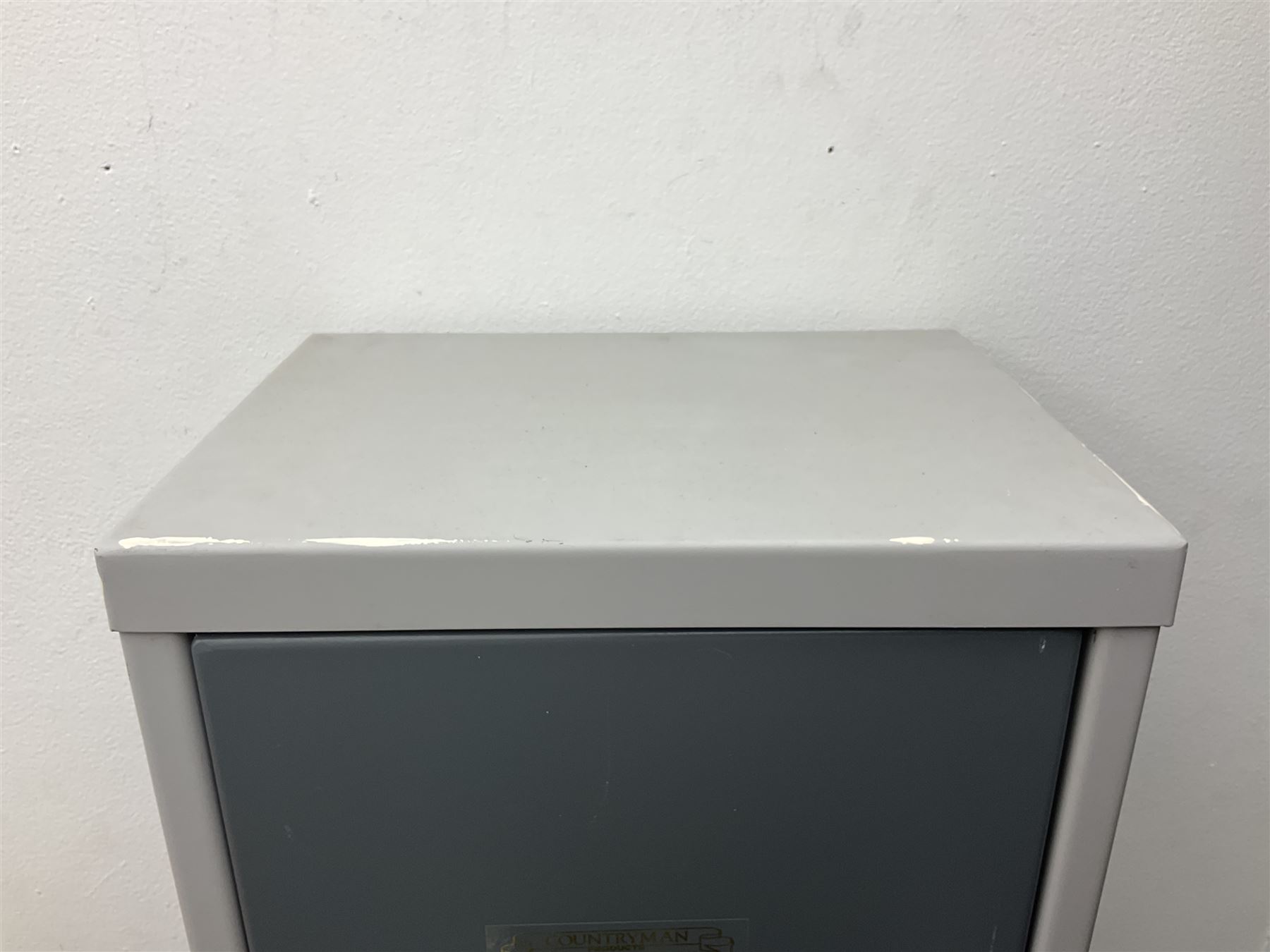 Two-tone grey steel wall-mounting gun cabinet by Sambell Engineering to accommodate six guns with fixed shelf over, gun space int. H132cm W36.5cm D23.5cm, the single double-locking door with two sets of keys, ext. H154cm W37cm D27cm