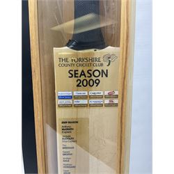 Two signed Yorkshire County cricket bats, bearing signatures including Anthony McGrath, Jacques Rudolph, Michael Vaughn and Matthew Hoggard, etc, both within glazed presentation boxes, box H86.5cm, together with a framed Darren Gough signed presentation print by Gary Keane