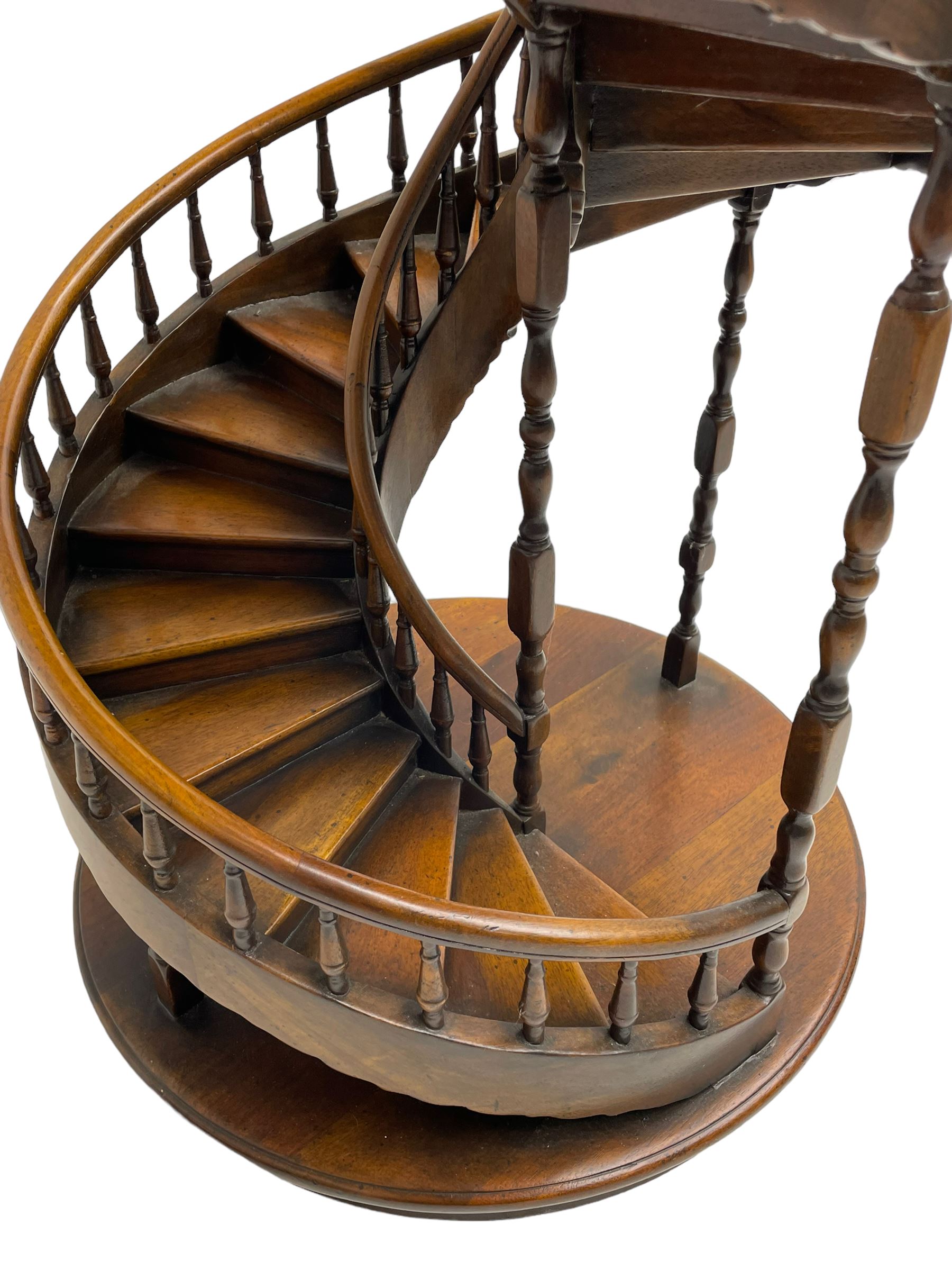 Miniature fruitwood spiral staircase, turned newel posts and balusters, rounded handrail, on circular moulded base