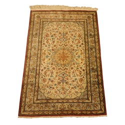  Quoom silk rug, the rectangular field with circular motif on an ivory ground surrounded by floral tendrils and shaped spandrels, within multiple borders incorporating a small scripted panel, in mauve, pale blue, black, ivory, red pink, browns and ochre, W97cm L156cm Provenance: This lot was gifted to the vendor who worked for the Royal Family of Oman  