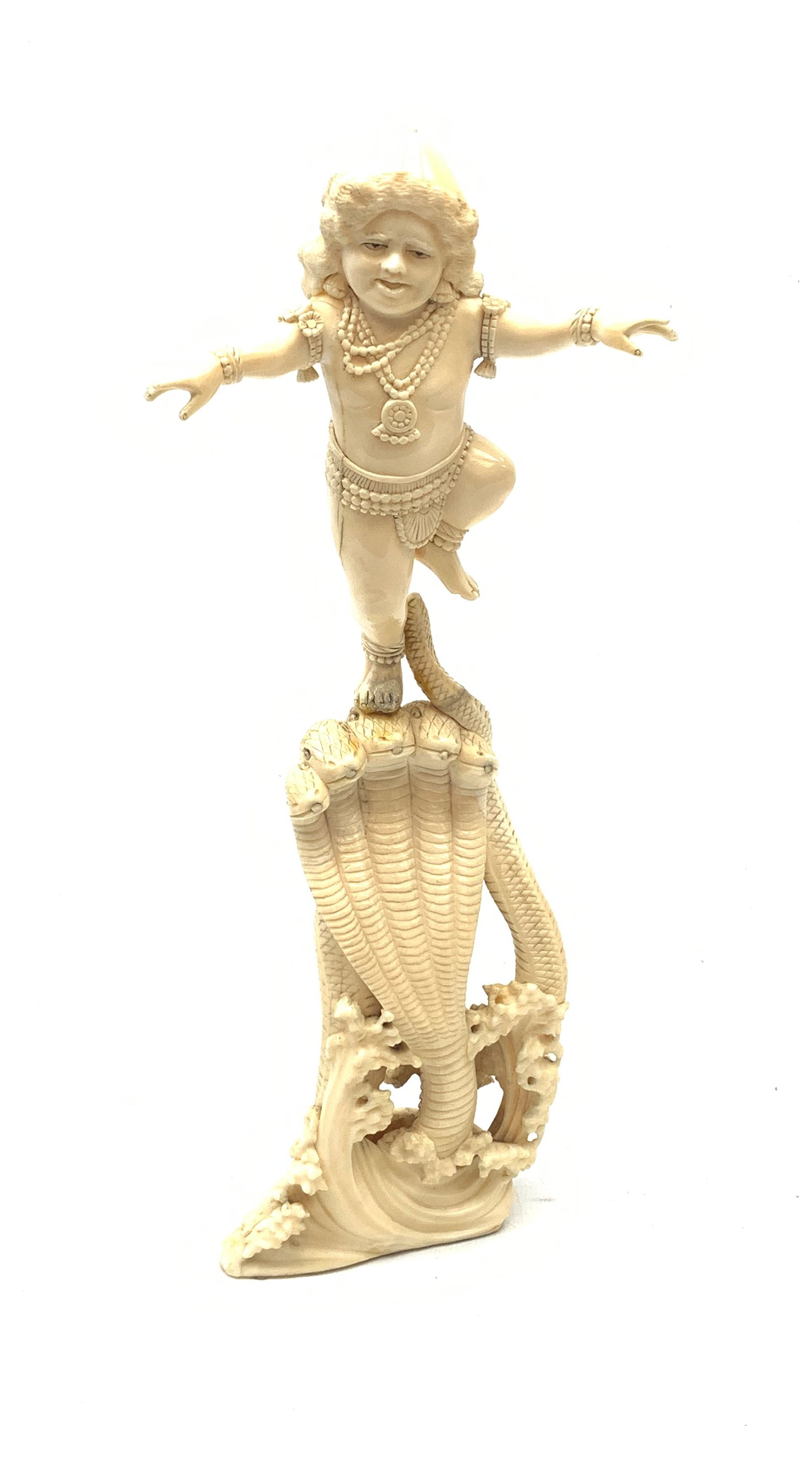 A large Japanese carved ivory okimono, modelled as a figure stood upon one leg with arms outstretched, upon a five headed serpent emerging from waves, H30cm.