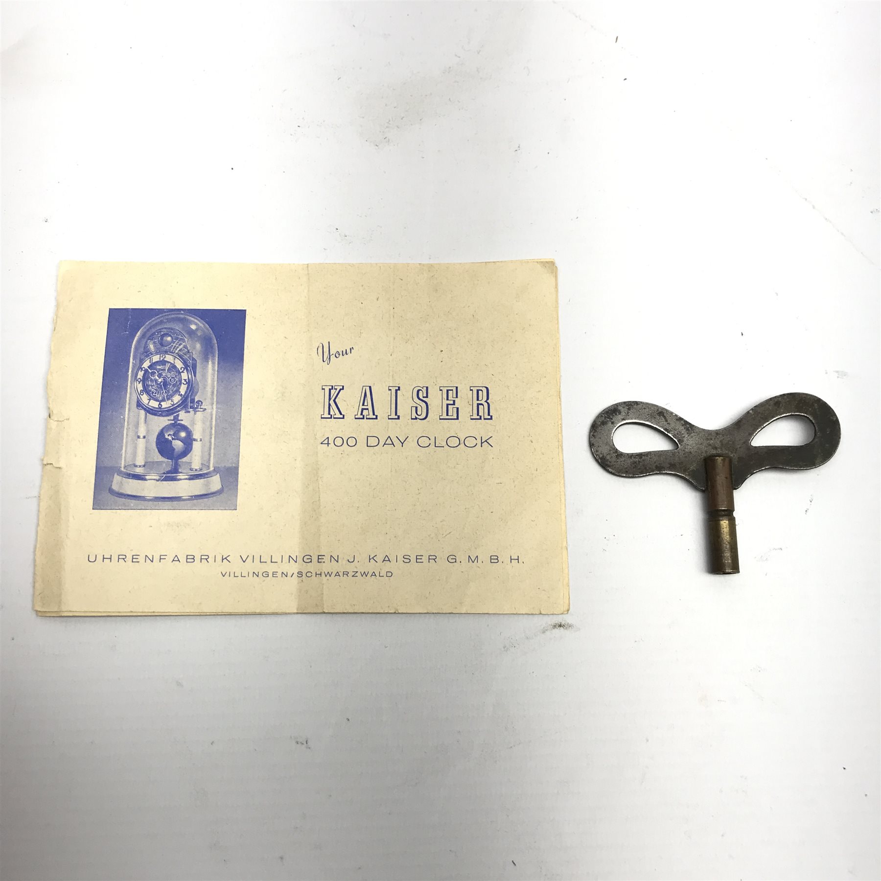 1950s Kaiser 'Universe' 400 day anniversary clock, moonphase dial with Arabic chapter ring decorated with the zodiac signs, globe pendulum, under glass dome, H27cm