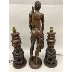 Pair of 20th century carved wood table lamp with African busts and figures, together with a carved wooden figure and soapstone figure, lamps H44cm