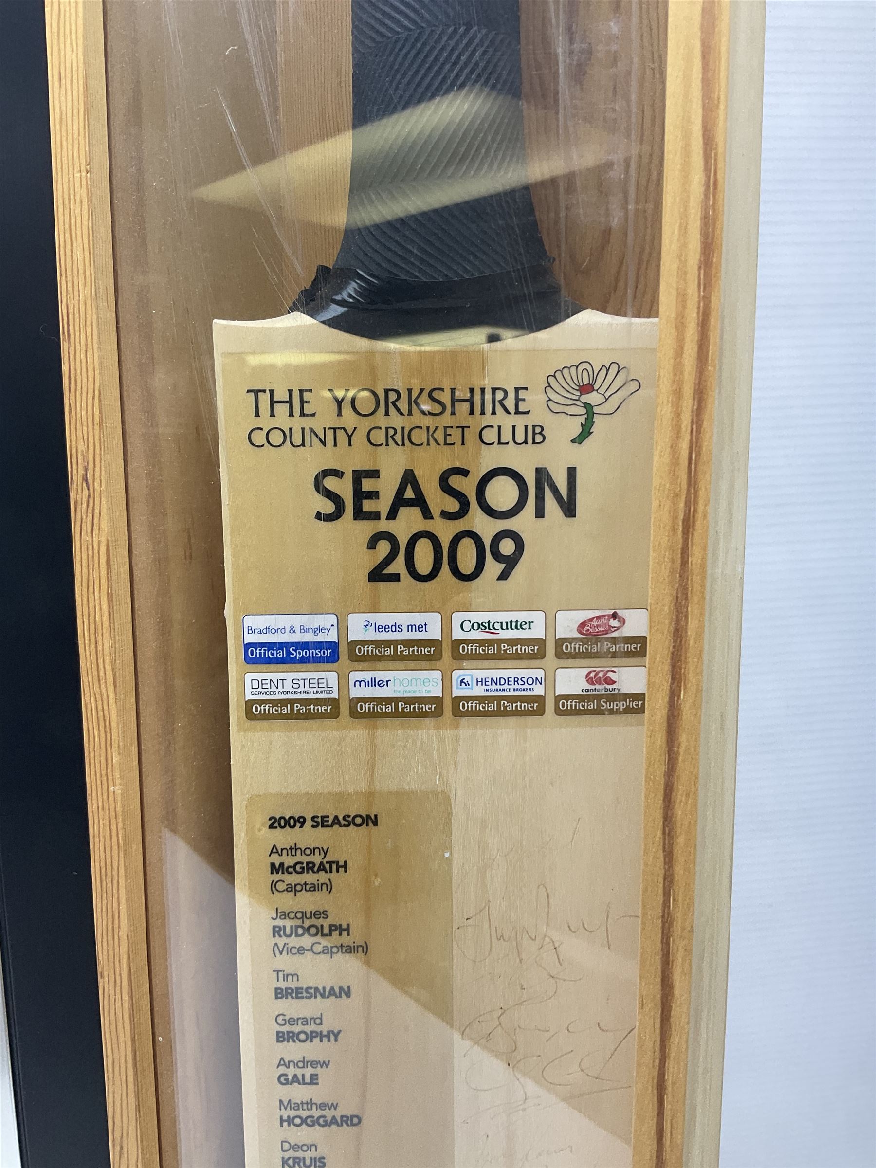 Two signed Yorkshire County cricket bats, bearing signatures including Anthony McGrath, Jacques Rudolph, Michael Vaughn and Matthew Hoggard, etc, both within glazed presentation boxes, box H86.5cm, together with a framed Darren Gough signed presentation print by Gary Keane